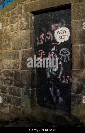'Why Me' street art girl on door on next to brick wall on slopes of Calton Hill Edinburgh Stock Photo