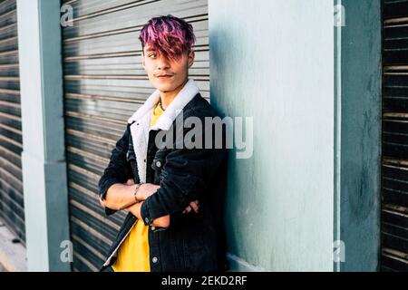 Portrait of handsome and young teenager boy man with violet diversity alternative hair look style - concept of modern people student age Stock Photo