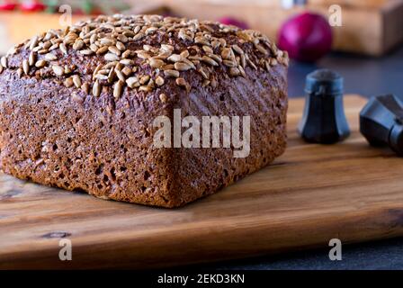 A loaf of sunflower seed bread on a wooden board Stock Photo