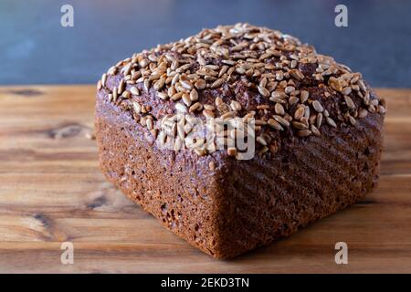 A loaf of sunflower seed bread on a wooden board Stock Photo