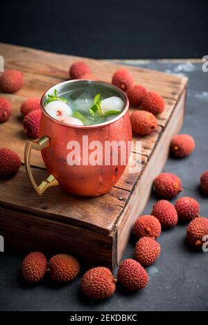 Fresh lychee moscow mule on the rustic background. Selective focus. Shallow depth of field. Stock Photo