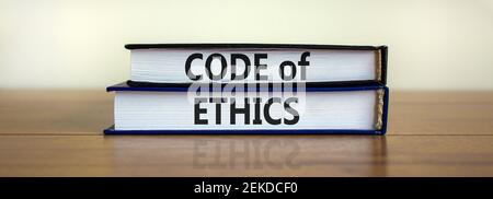 Code of ethics symbol. Concept words 'Code of ethics' on books on a beautiful wooden table, white background. Business and code of ethics concept. Cop Stock Photo