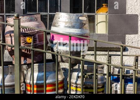 Metal beer casks piled up outside a pub for collection and reuse. Stock Photo