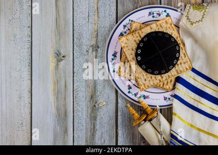 Pesach Passover celebrating symbols of great Jewish family holiday traditional matzah, seder, kippah and tallit, torah scroll Stock Photo