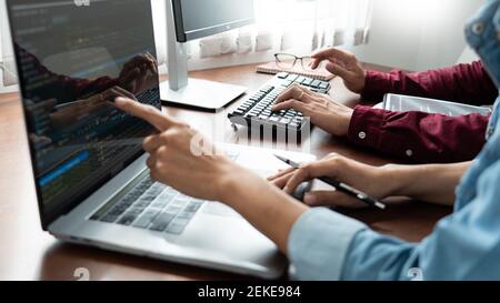 Team of Programmer working to find solution to problem and coding technologies in a software developing company office Stock Photo