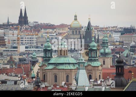 Historical centre of Prague with Saint Nicholas' Church (Kostel svatého Mikuláše) and the Old Town Hall (Staroměstská radnice) in Old Town Square and the National Museum (Národní muzeum) in Wenceslas Square (Václavské náměstí) pictured from the Hanavský Pavilon in Letná Park (Letenské sady) in Prague, Czech Republic. The church of Saint Ludmila (Kostel svaté Ludmily) is seen in the background at the left. The towers of Saint Gall's Church (Kostel svatého Havla) are seen next to the medieval tower of the Old Town Hall at the right. Stock Photo