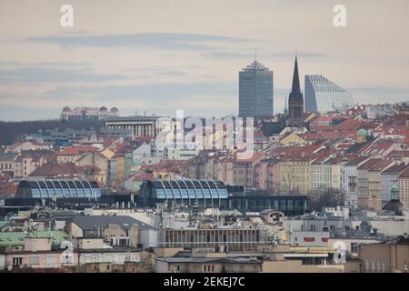 Controversial new buildings raised over the historical panorama of Prague pictured from Letná Park (Letenské sady) in Prague, Czech Republic. The building pictured from left to right in the background: Don Giovanni Hotel with oriental cupolas, Olšanka Hotel, Palác Vinohrady formerly known as the Strojimport Building, the neo-Gothic church of Saint Procopius (Kostel svatého Prokopa) and the Crystal Building. The black building in the foreground is the Florentinum Business Centre. Stock Photo
