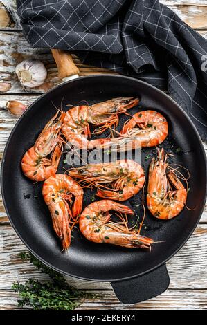 Grilled tiger shrimps Prawns with spice and lemon in a pan. White wooden background. Top view Stock Photo