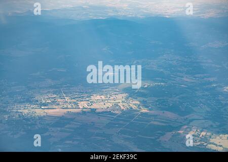 Italy aerial above high angle view from window of airplane on houses farm fields with sun rays and sunlight over village in summer near Rome Stock Photo
