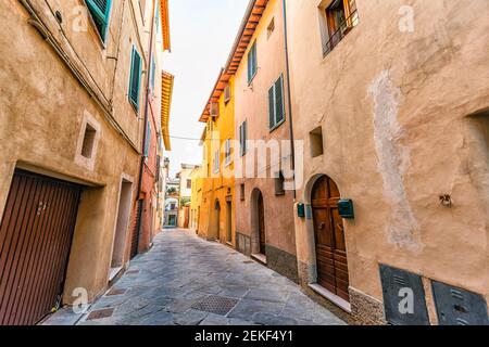 Chiusi, Italy empty road street in small historic medieval town village in Tuscany nobody orange yellow bright vibrant colorful houses Stock Photo