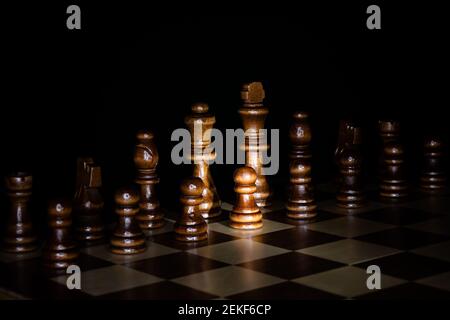 Dark wood chess pieces with black background. Stock Photo