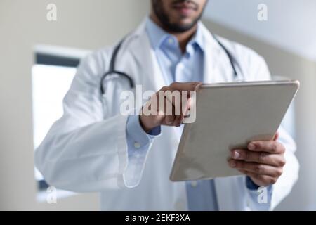 Mixed race male doctor using digital tablet Stock Photo