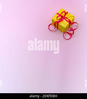 yellow gift box with red ribbon, yellow gift on pink background, pink background Stock Photo