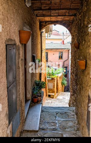 Chiusi, Italy narrow empty small alley street in historic town village in Tuscany walls of houses and stone vault arch Stock Photo