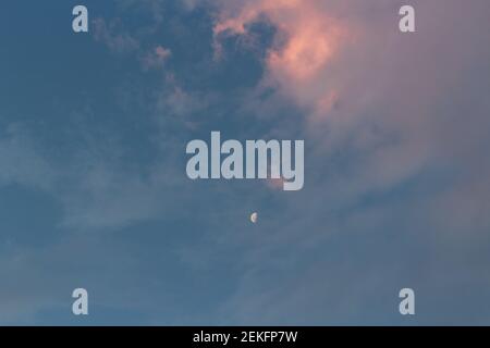 Crescent moom in a cloudy sky at sunset Stock Photo