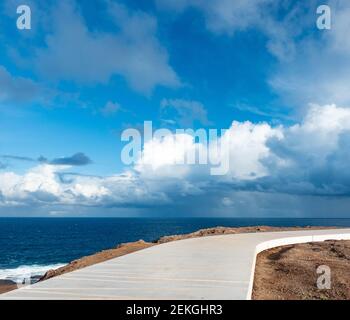 Coastal footpath with storm clouds on the horizon Stock Photo