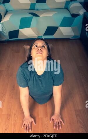 young lady doing a stretched yoga pose looking up in the salon Stock Photo