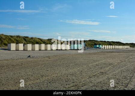 Beach cabins before beach oat in the dunes on the North Sea coast, in the Netherlands on Zeeland with blue sky Stock Photo
