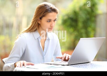 Concentrated entrepreneur working with laptop in a garden at home Stock Photo