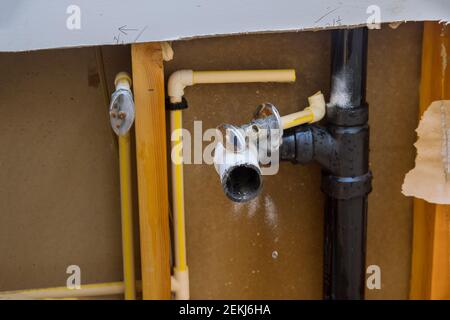 Repair plumbing line with damaged leaking water hose pipe in a bathroom Stock Photo