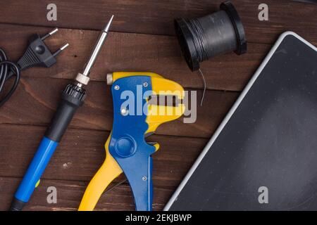 Flatlay on the topic of radio electronics repair. Soldering iron and wire stripper tool. Place for text. Stock Photo