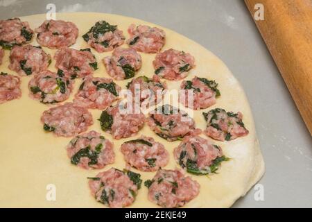 Process of cooking homemade dumplings. Minced meat with spinach on thin crust. Close-up, selective focus. Stock Photo