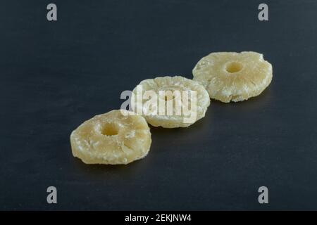 Dried pineapple slices on a dark background Stock Photo