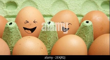 Emotional chicken eggs in a tray. Different grimaces drawn on chicken eggs. Stock Photo