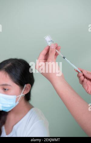 Hispanic female doctor preparing injection to vaccinate Stock Photo