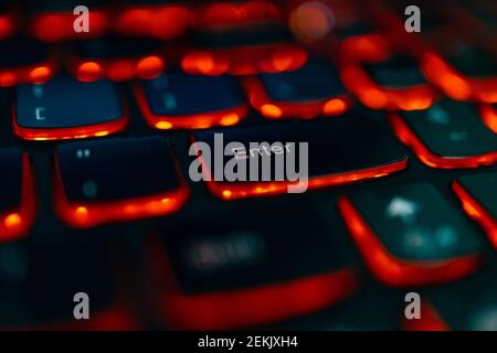 Old laptop with red highlighted keyboard with focus on Enter key Stock Photo