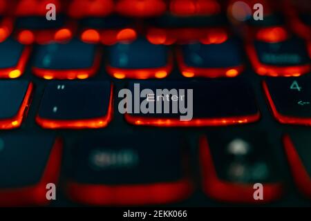 Old laptop with red highlighted keyboard with focus on Enter key Stock Photo