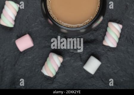 A black cup of coffee with marshmallows on a dark background Stock Photo