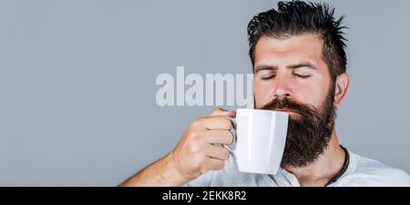 Good morning, man tea. Handsome man holds cup of coffee, tea. Hipster male with cup of fresh coffee. Morning concept Stock Photo