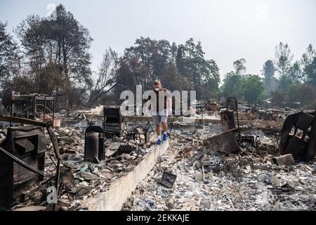 TALENT, ORE - SEPTEMBER 18, 2020: Zach Kuhlow checks the remnants of his house for anything salvagable. His son, who is now 10, was born inside the house. In Talent, about 20 miles north of the California border, homes were charred beyond recognition. Across the western US, at least 87 wildfires are burning, according to the National Interagency Fire Center. They've torched more than 4.7 million acres -- more than six times the area of Rhode Island. Credit: Chris Tuite/imageSPACE/Sipa USA