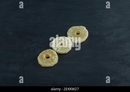 Dried pineapple slices on a dark background Stock Photo
