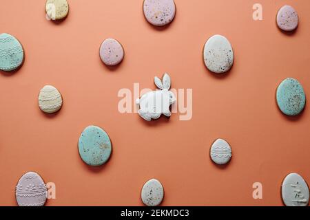 Image of decorated homemade gingerbread cakes in the shape of rabbit and eggs isolated on orange background Stock Photo