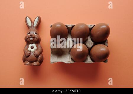 High angle view of chocolate rabbit and eggs prepared for Easter isolated on orange background Stock Photo