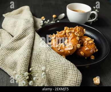 Donuts and black coffee over rustic background. Stock Photo