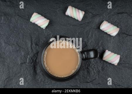 A black cup of coffee with marshmallows on a dark background Stock Photo
