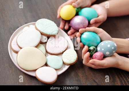 Close-up of gingerbread cakes on the plate with Easter eggs in children's hands for Easter holiday Stock Photo