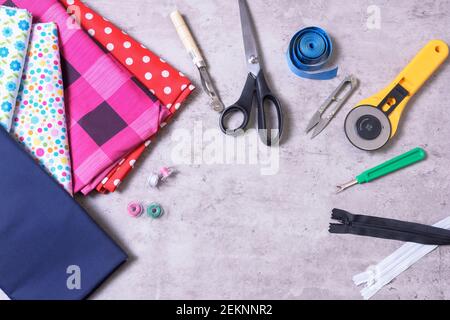 Sewing items and accessories for needlework, fabric, thread, scissors, clasp, cutter, tape measure, on gray background Stock Photo