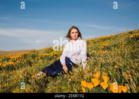 Young female in California desert poppy field on spring afternoon Stock Photo