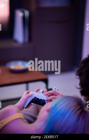 Girl with next gen controller in her hands playing games at home. Stock Photo