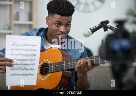 man showing how to play guitar with camera Stock Photo