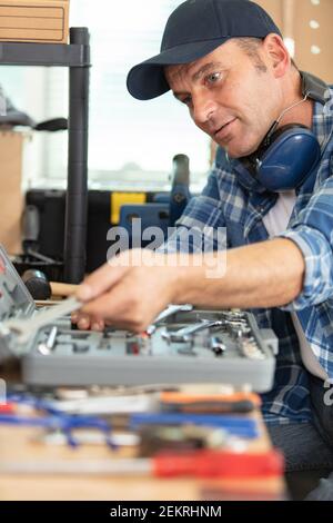 happy repairmanlooking for tools in toolbox Stock Photo