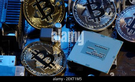 Bitcoin mining. BTC and CPU central processor on the digital technology pc motherboard. Market trading cashless e-commerce. Gold bitcoin cryptocurrency isolated on computer board. New virtual money Stock Photo
