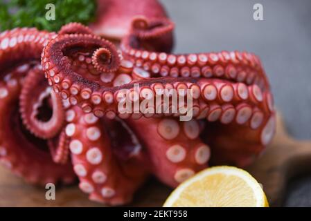 Octopus food cooked salad seafood squid cuttlefish, Boiled octopus tentacles with lemon on cutting board Stock Photo