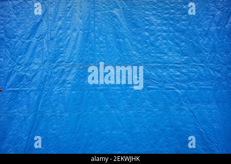 details of the thick tarpaulin used by traditional market traders to withstand rain and sun. blue tarp texture for design material or photo background Stock Photo