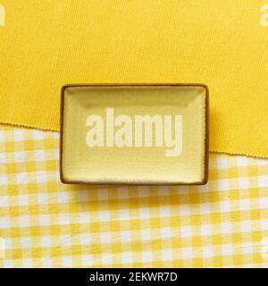 Empty plate on yellow fabric background. top view Stock Photo