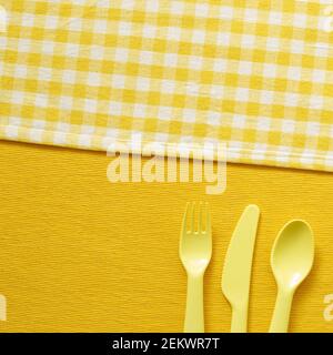 Fork knife spoon on yellow fabric background. top view, copy space Stock Photo